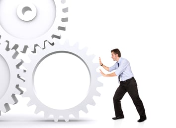 business man pushing cogwheel
